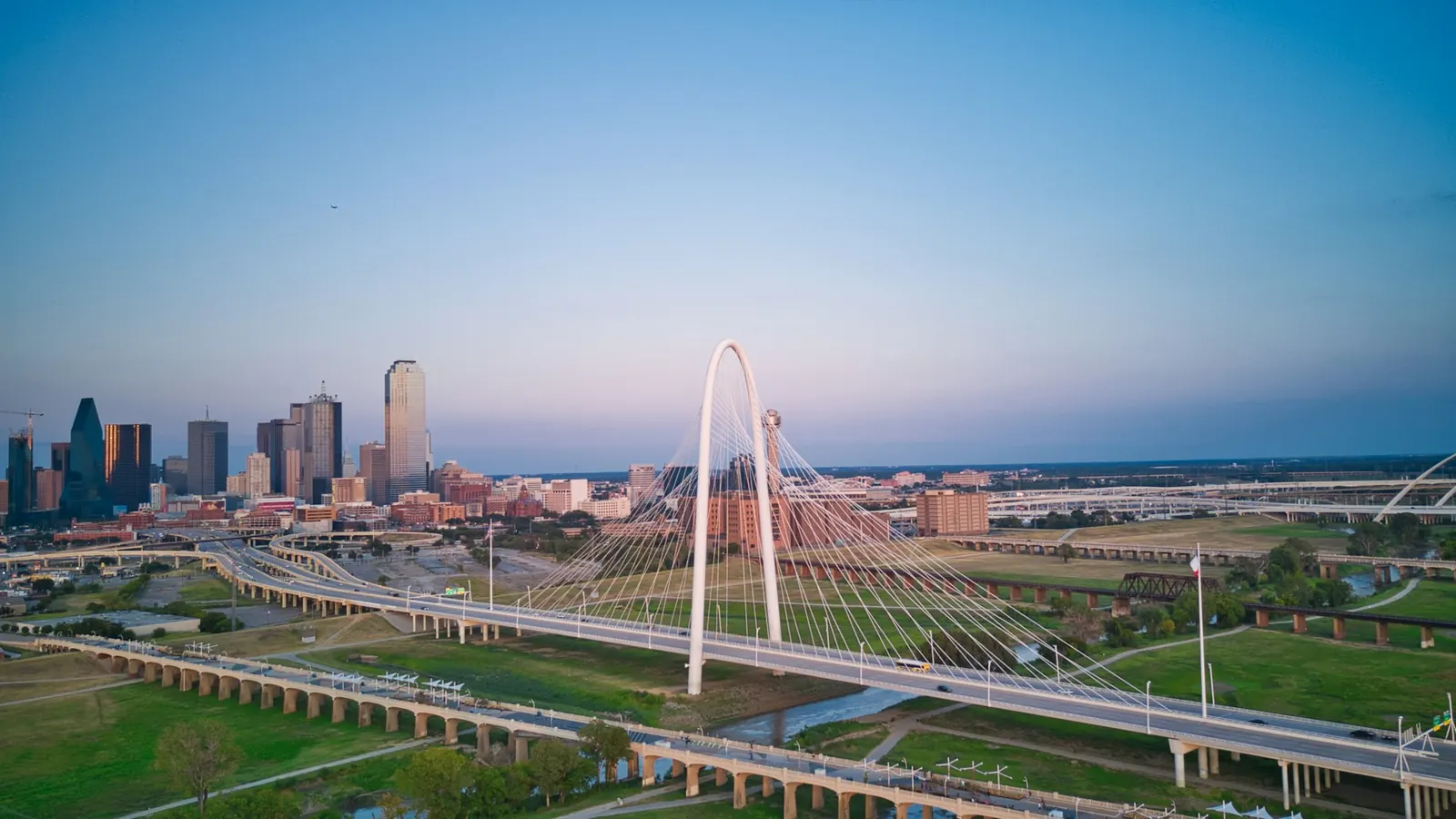 an aerial view of a city with a bridge in the foreground