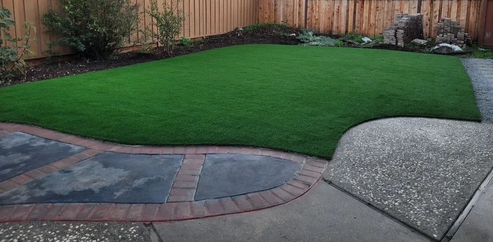 Backyard artificial turf installation with patio